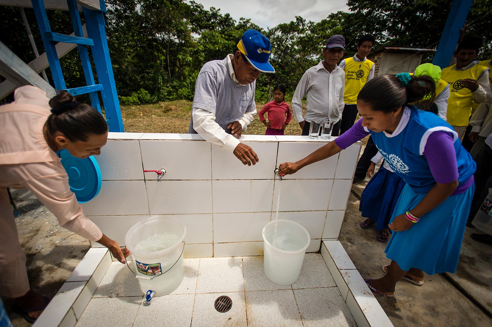 People collect safe water from the Water Mission safe water treatment system.